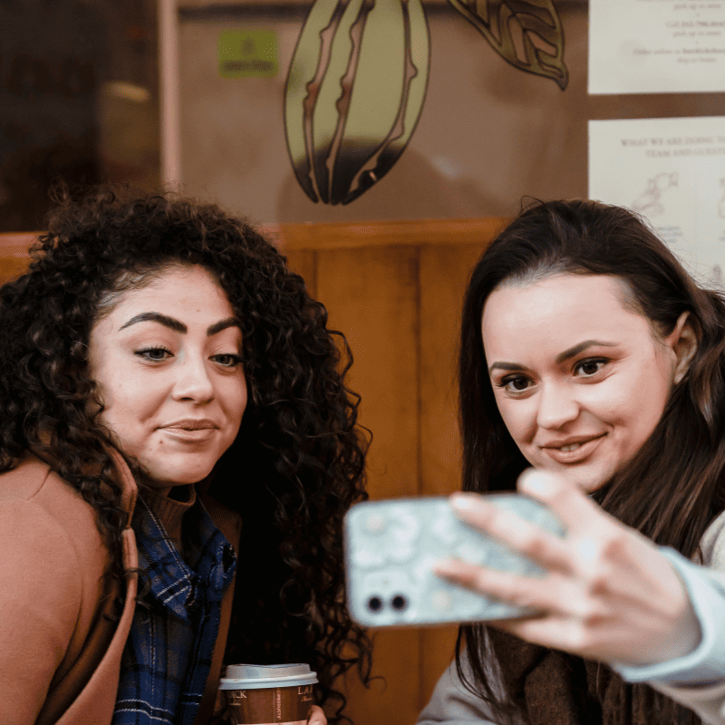 duas garotas da geracao z tirando uma self em café