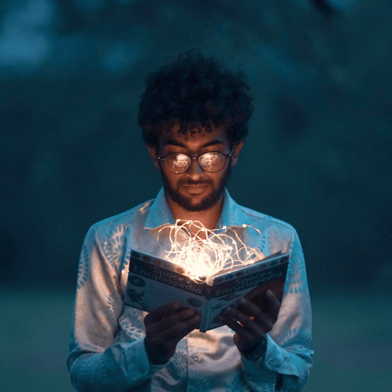 Um homem negro segurando um livro de histórias encantadoras